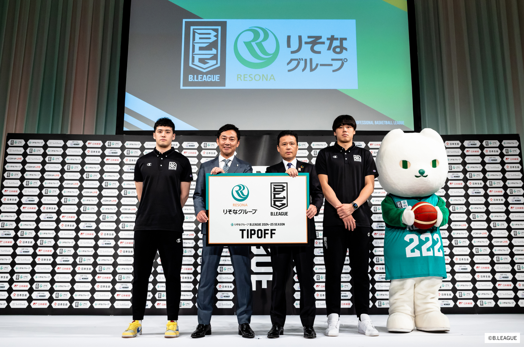 りそなグループとBリーグのロゴを持った島田チェアマンと南社長を中心に中村選手と三谷選手、りそにゃが並んで記念撮影をしている写真