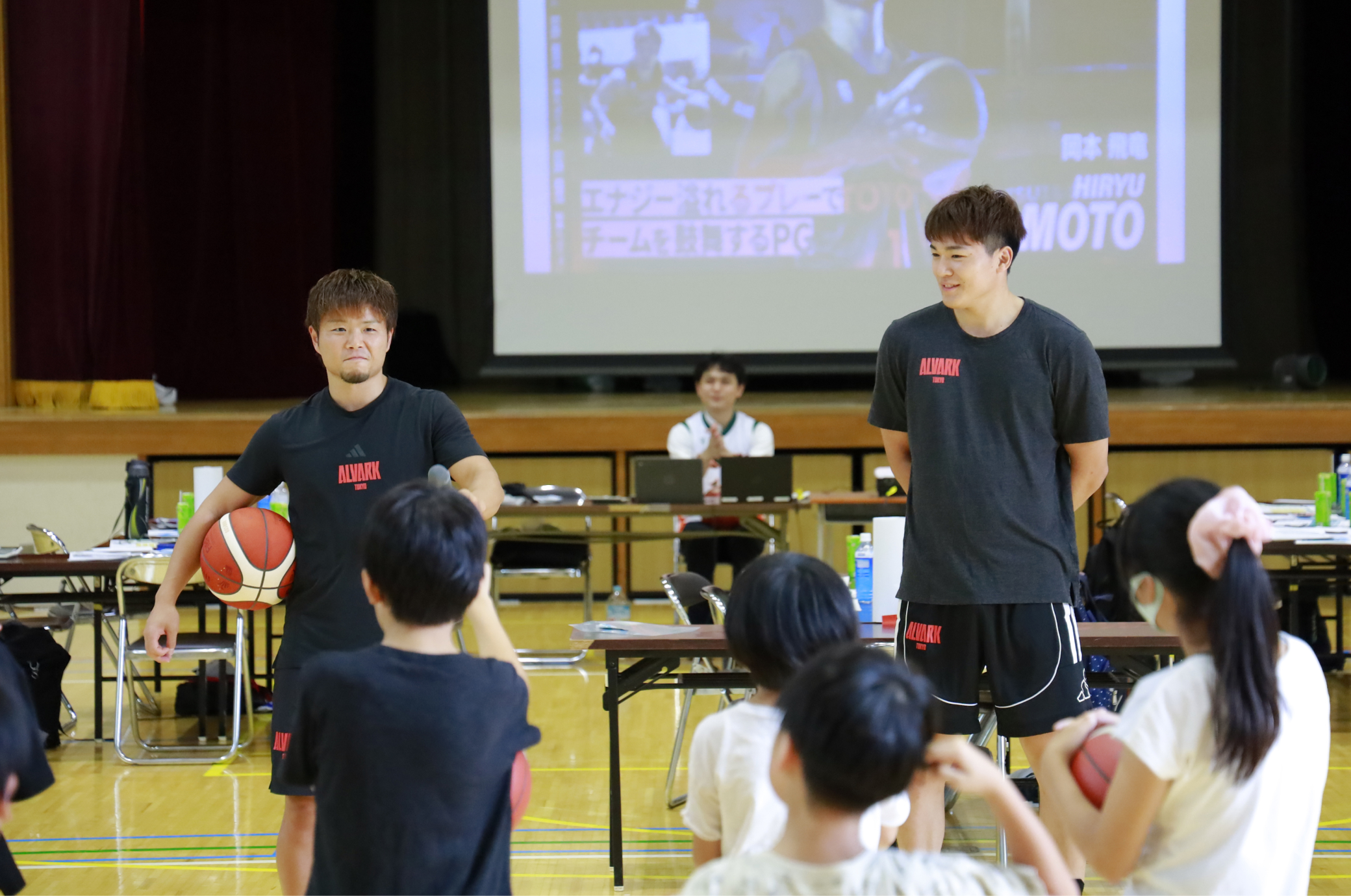 アルバルク東京の岡本選手と安藤選手が子供たちの前で自己紹介している写真