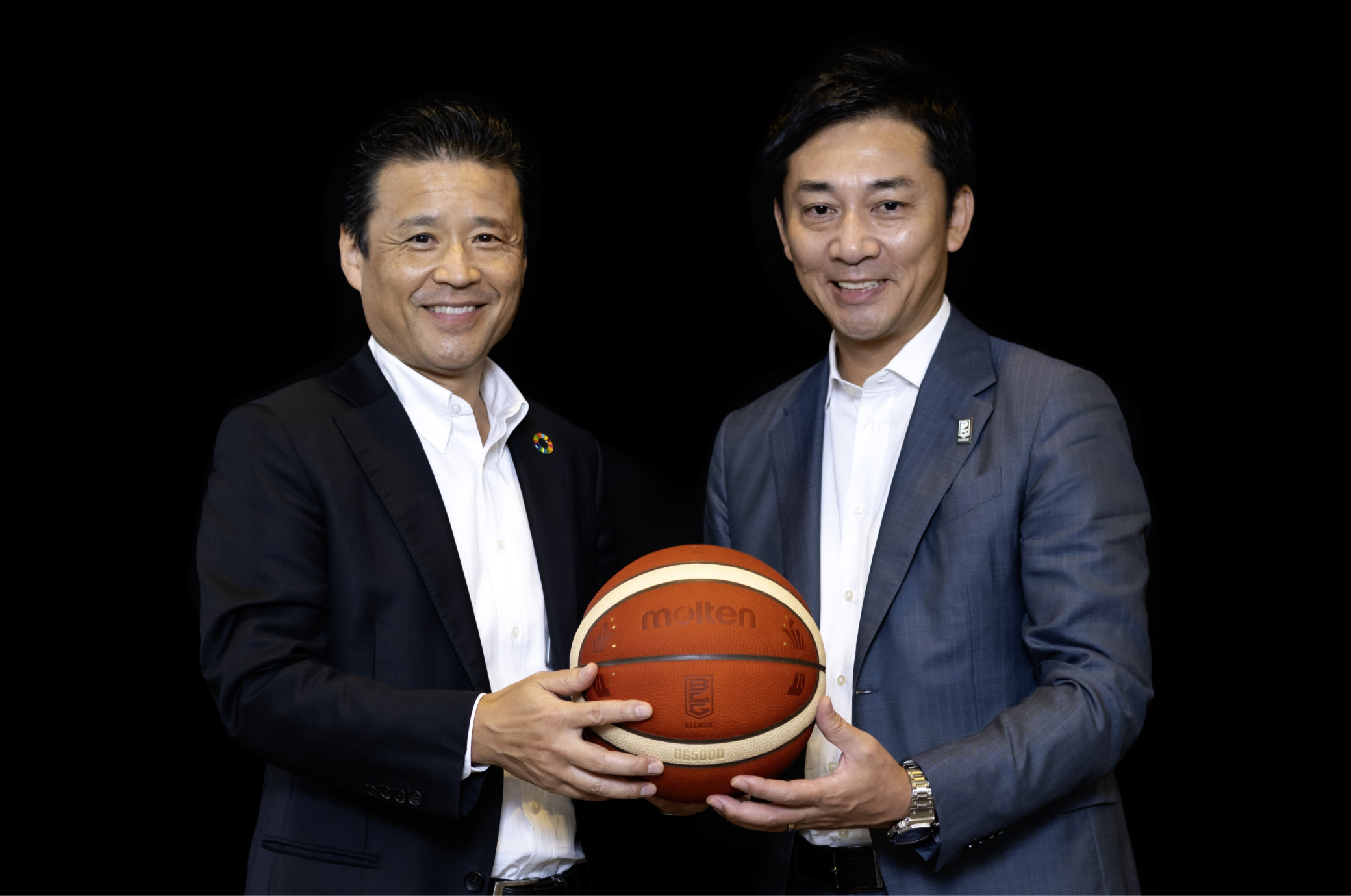 南社長と島田チェアマンが二人の間にある一つのボールを胸の下で持っている写真