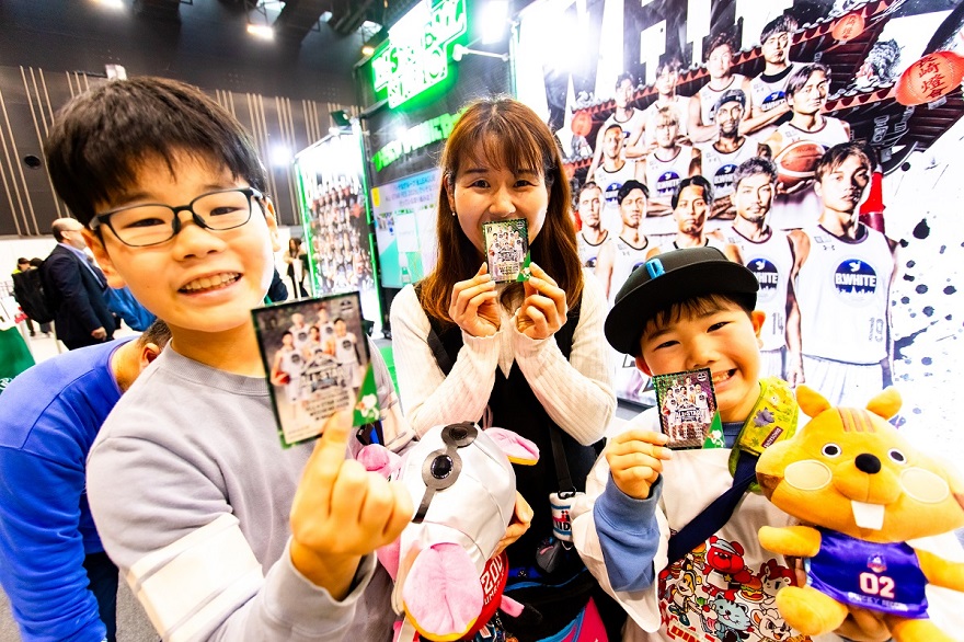 配布されたカードを笑顔で手にする来場者