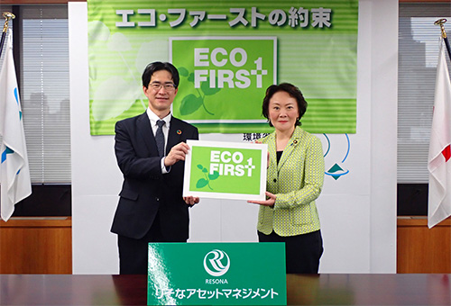 Two presenters holding an Eco-First commitment panel during the announcement