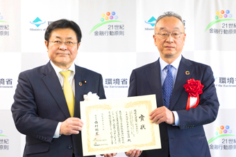 表彰式で表彰状を手に並ぶ受賞者2名の様子